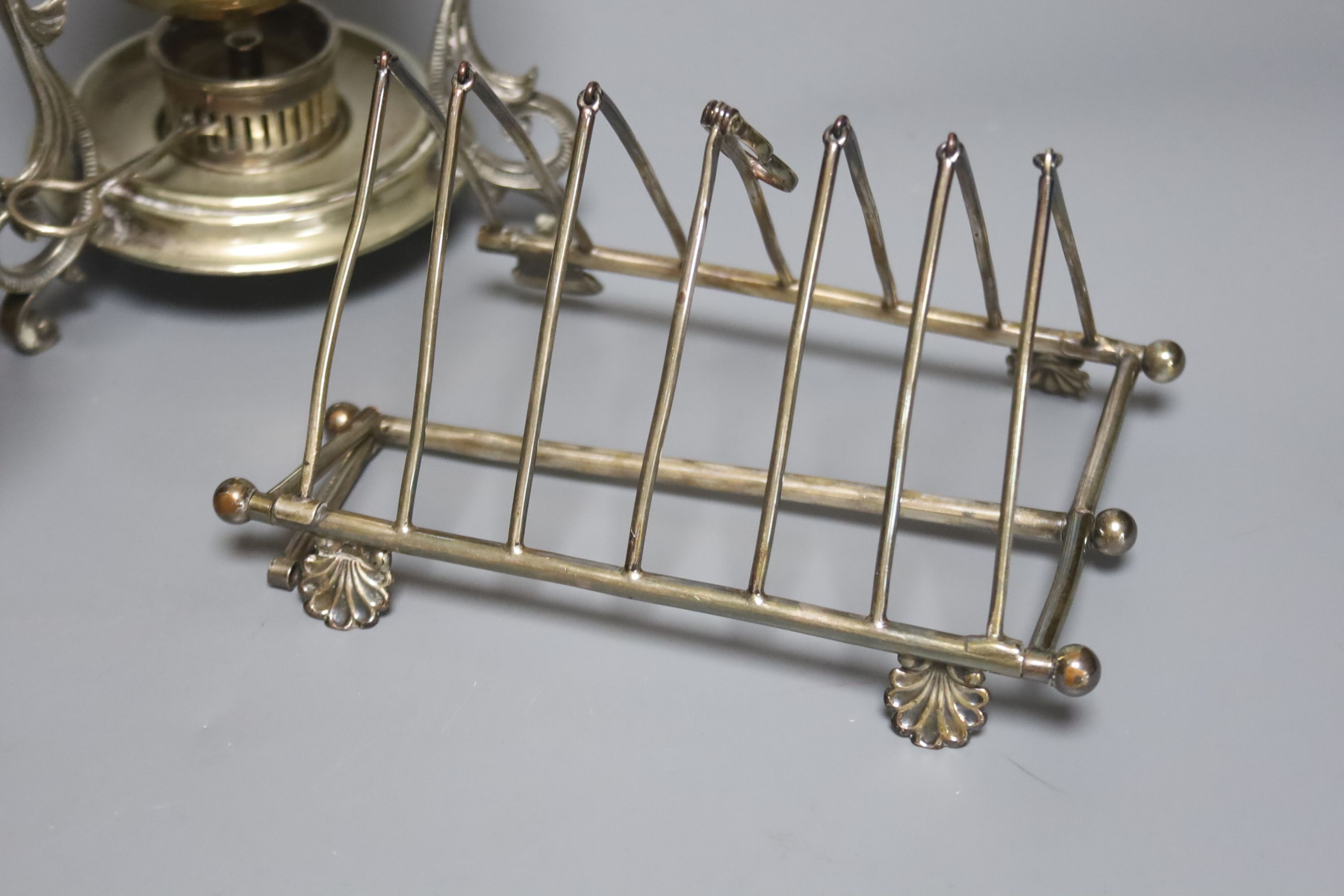 An electroplate nautilus shell spoon warmer, an egg coddler and a folding toast rack, height 23cm